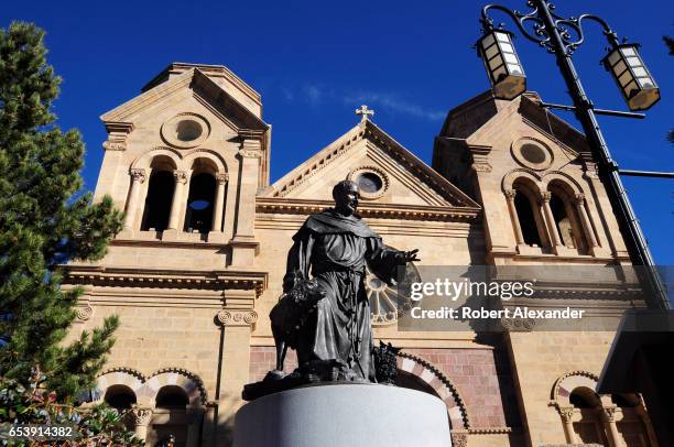 Bronze statue of Saint Francis of Assisi stands in front of the Cathedral Basilica of Saint Francis of Assisi in downtown Santa Fe, New Mexico. The...