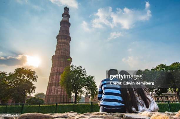 couple gazing at qutub minar - qutab minar stock pictures, royalty-free photos & images