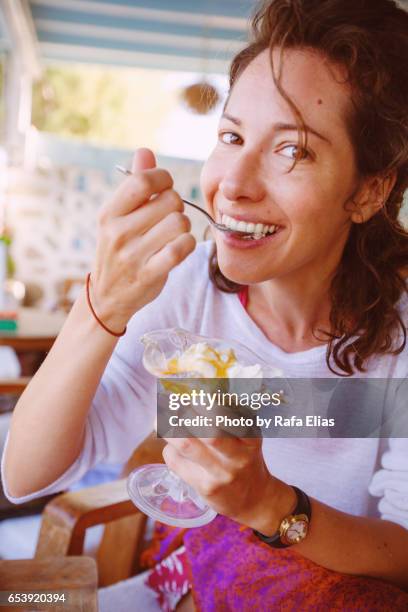 pretty woman eating yogurt - greek woman stock-fotos und bilder