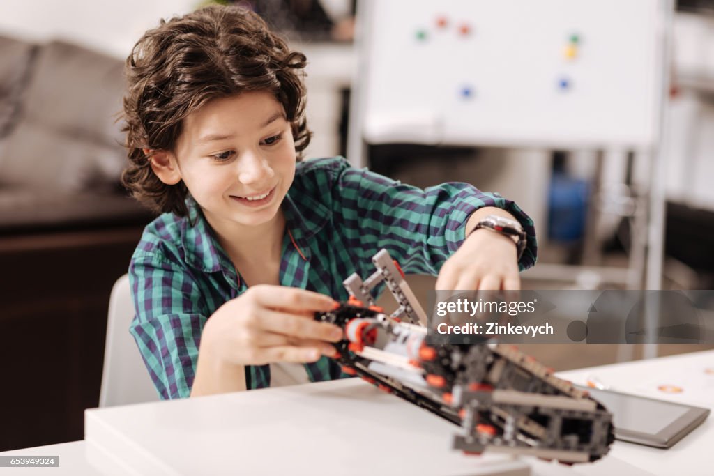 Amused Teen Boy Programming Digital Robot In The Studio High-Res Stock ...