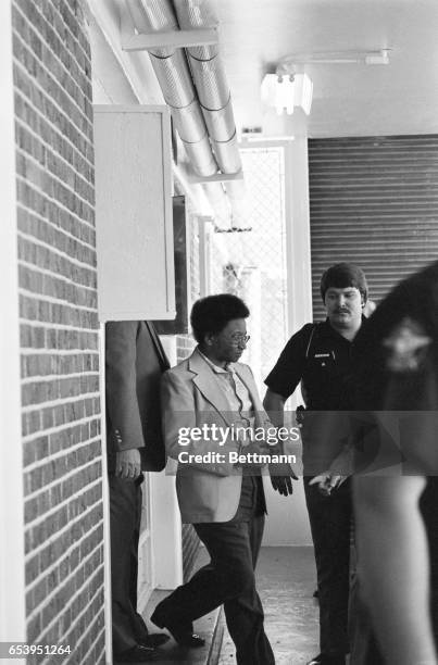 Handcuffed and closely guarded, Wayne Williams walks from Fulton County Jail to a car en route to court for a preliminary hearing June 23rd. Williams...