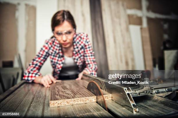 young carpenter, repairwoman using a circular saw - table saw stock pictures, royalty-free photos & images