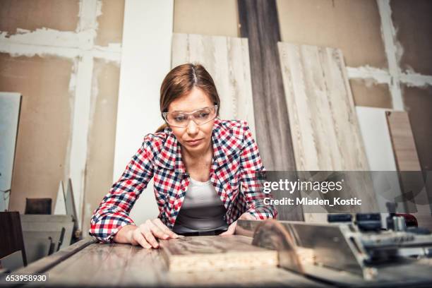 young female carpenter using a circular saw - table saw stock pictures, royalty-free photos & images