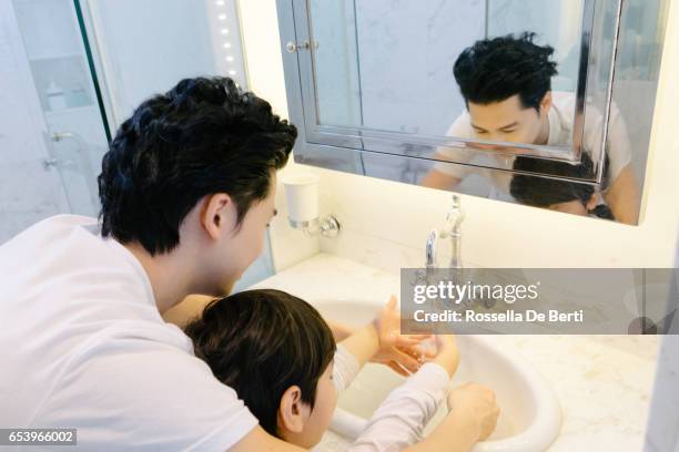 father and son washing hands with soap in bathroom - kin in de hand stock pictures, royalty-free photos & images