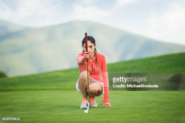 young hispanic women playing golf - golf putter stock pictures, royalty-free photos & images