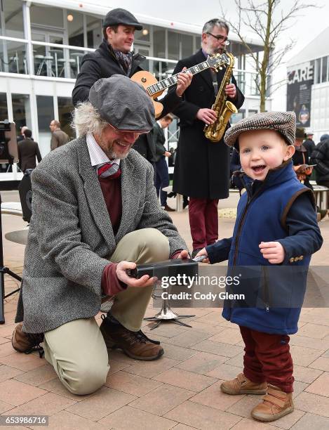 Cheltenham , United Kingdom - 16 March 2017; Harry Almond, age 2, from Thirsk, England, playes the cow bell with the "Hipcats" comprised of, from...