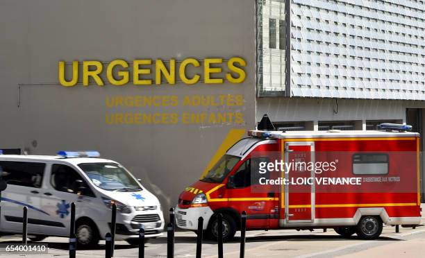 An ambulance and a firefighter truck drive in front of the emergency service of the Nantes CHU Hospital on March 16, 2017 in Nantes, western France....
