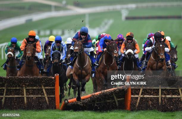 Arctic Gold' ridden by jockey Tom Humphries crashes through a hurdle in The Pertemps Network Final Handicap Hurdle Race on the third day of the...