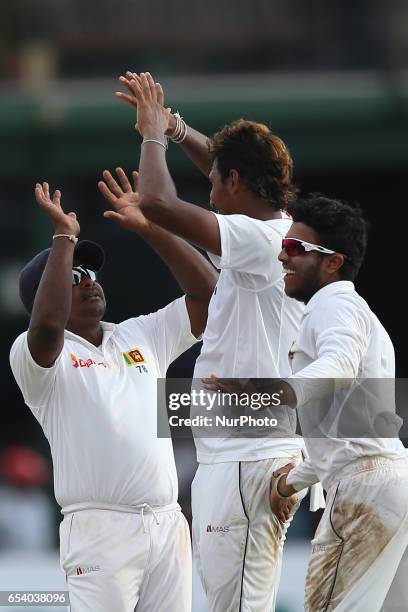 Sri Lanka's Suranga Lakmal is congratulated by captain Rangana Herath and Kusal Mendis after the dismissal of Bangladeshi batsman Sabbir Rahman...