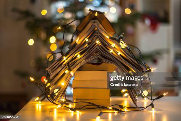 christmas tree formed with books and christmas lights - lacaosa stock-fotos und bilder