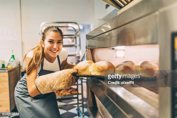 belle baker, retirer le pain chaud du four - baker smelling bread photos et images de collection
