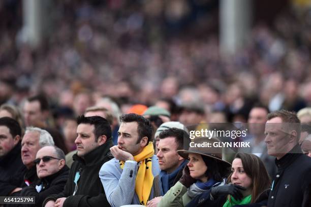 The crowd watch The Trull House Stud Mares' Novices' Hurdle Race on the third day of the Cheltenham Festival horse racing meeting at Cheltenham...