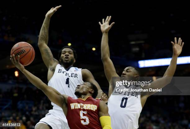 Keon Johnson of the Winthrop Eagles attempts a shot past Tyler Wideman and Avery Woodson of the Butler Bulldogs in the first half during the first...