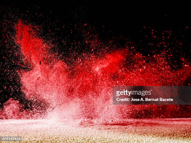 blackground of particles of white powder in ascending movement floating in the air produced by an impact - powder burst stock-fotos und bilder