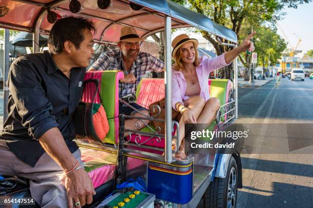 happy mature couple on vacation using tuktuk transport in thailand - rickshaw or tuk tuk or surrey or pedicab stock pictures, royalty-free photos & images