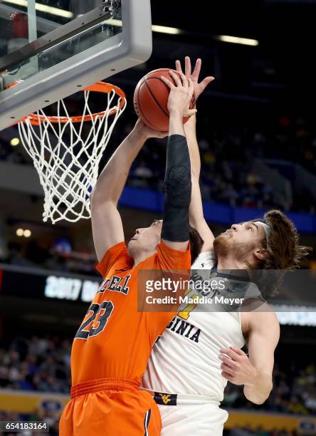 Zach Thomas of the Bucknell Bison shoots the ball against Nathan Adrian of the West Virginia Mountaineers during the first round of the 2017 NCAA...