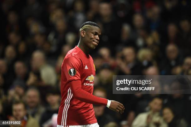 Manchester United's French midfielder Paul Pogba leaves the pitch injured during the UEFA Europa League round of 16 second-leg football match between...