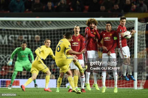 Rostov's Ecuadorian midfielder Christian Noboa curls a last minute free kick around the Manchester United defensive wall composed of Manchester...