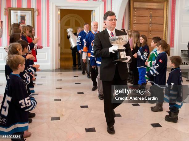 Craig Campbell of the Hockey Hall of Fame carries in the original bowl of the Stanley Cup during the Stanley Cup Homecoming as part of the Stanley...