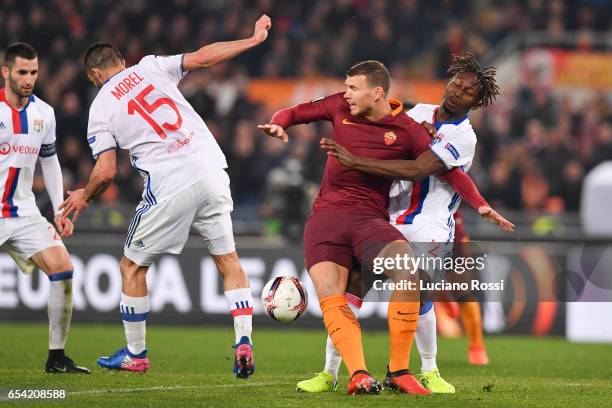 Roma player Edin Dzeko competes with Olympique Lyonnais player Mapou Yanga-Mbiwa during the UEFA Europa League Round of 16 second leg match between...