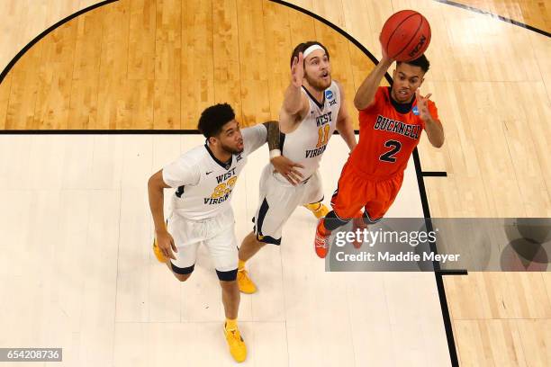 Nathan Adrian of the West Virginia Mountaineers blocks the ball against Stephen Brown of the Bucknell Bison during the first round of the 2017 NCAA...