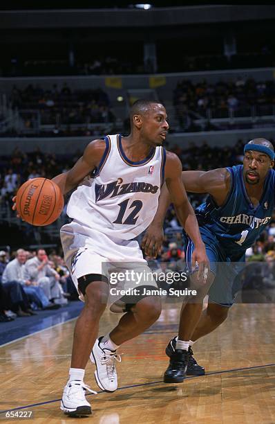 Chris Whitney of the Washington Wizards moves with the ball as Baron Davis of the Charlotte Hornets guards him during the game at the MCI Center in...