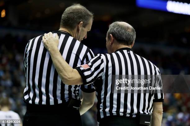 Officials Randy Heimerman and Ed Corbett meet in the second half of the game between the Vermont Catamounts and Purdue Boilermakers during the first...