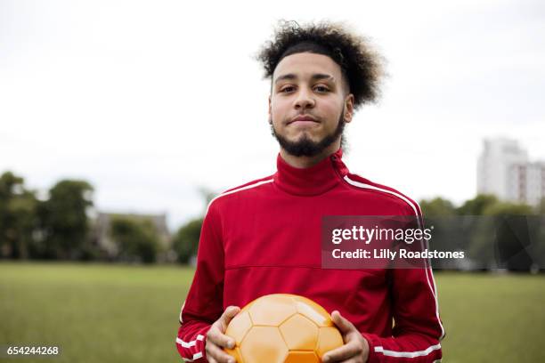 young guy holding ball in park - indian football stock pictures, royalty-free photos & images