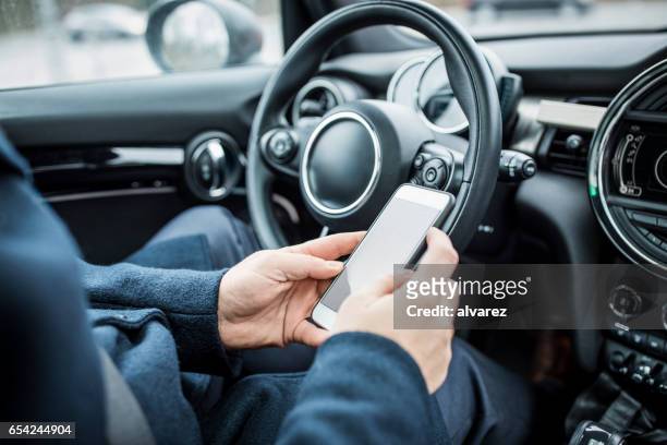 man using mobile phone in car - business man driving stock pictures, royalty-free photos & images