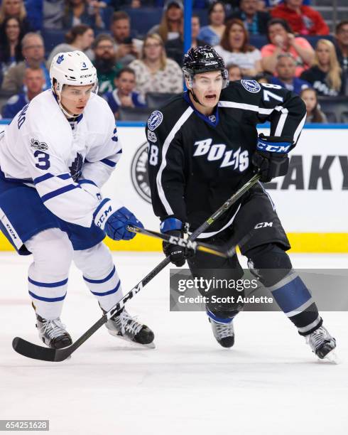 Byron Froese of the Tampa Bay Lightning skates against Alexey Marchenko of the Toronto Maple Leafs during the third period at Amalie Arena on March...