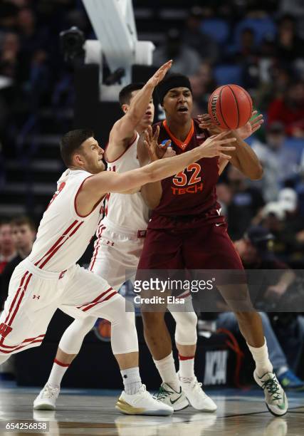 Zak Showalter of the Wisconsin Badgers bats the ball away against Zach LeDay of the Virginia Tech Hokies in the first half during the first round of...
