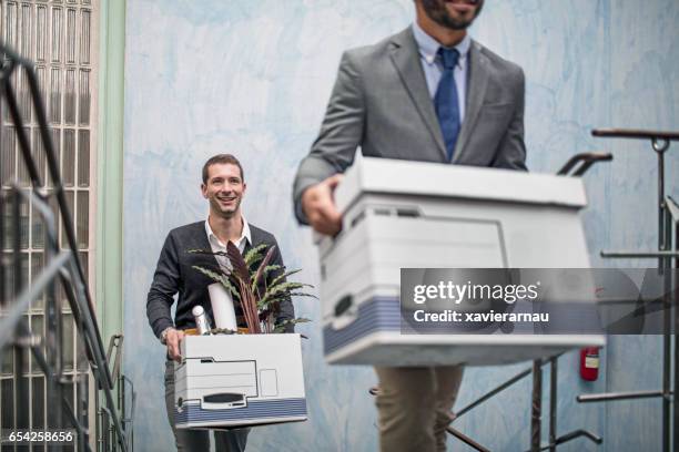 geschäftsleute mit habseligkeiten auf der treppe im büro - moving office stock-fotos und bilder