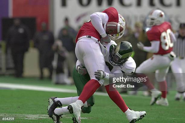 Ronnie Ghent of Louisville loses control of the ball after he is hit by Rick Crowell of Colorado State during the first half of the Liberty Bowl in...