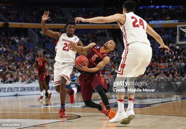 Justin Robinson of the Virginia Tech Hokies drives against Khalil Iverson and Bronson Koenig of the Wisconsin Badgers in the first half during the...