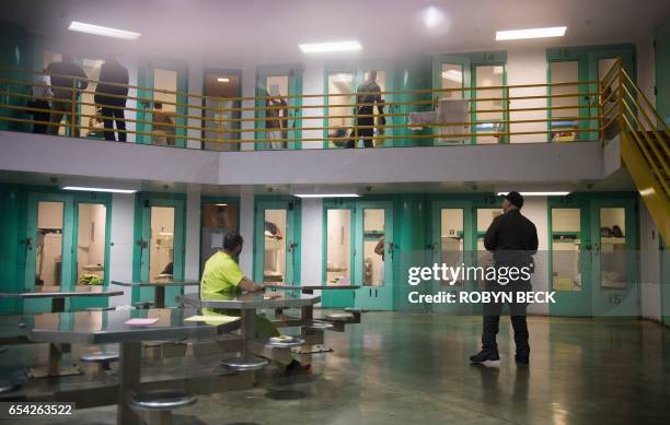 Sheriff's deputy talks to an immigration detainee in a high security housing unit at the Theo Lacy Facility, a county jail which also houses...