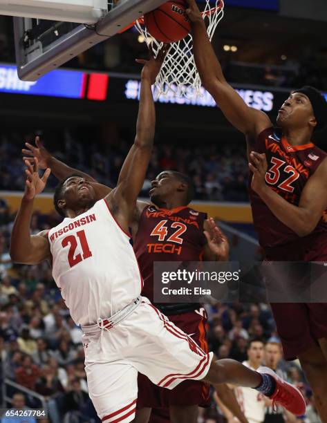 Khalil Iverson of the Wisconsin Badgers shoots against Ty Outlaw and Zach LeDay of the Virginia Tech Hokies in the first half during the first round...