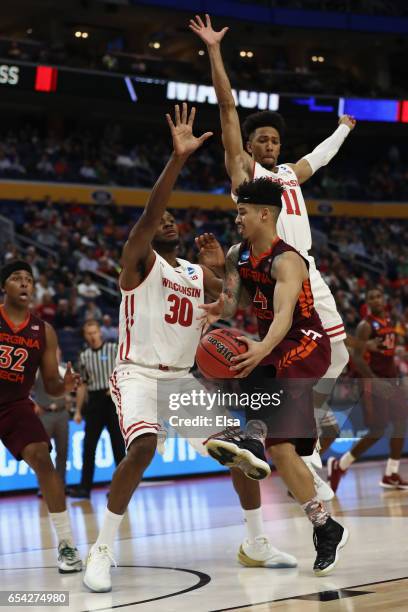 Seth Allen of the Virginia Tech Hokies looks to pass to teammate Zach LeDay against Vitto Brown and Jordan Hill of the Wisconsin Badgers in the...