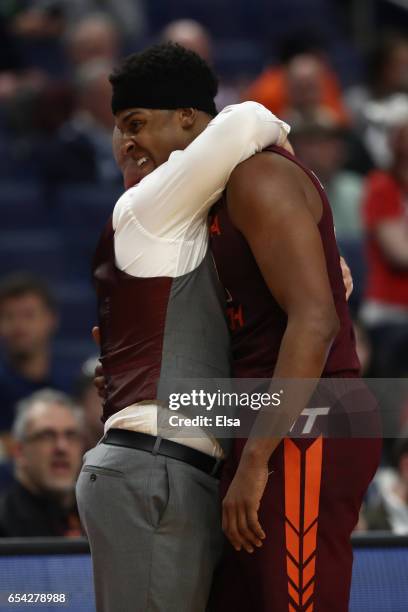 Zach LeDay of the Virginia Tech Hokies hugs head coach Buzz Williams after he fouls out of the game in the second half against the Wisconsin Badgers...