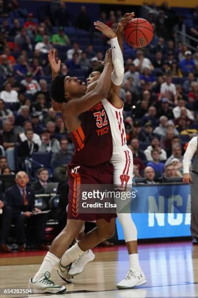 Zach LeDay of the Virginia Tech Hokies passes the ball against Jordan Hill of the Wisconsin Badgers in the second half during the first round of the...