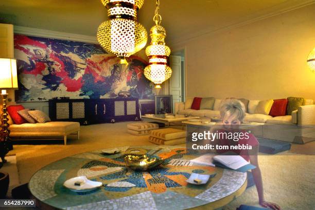 American actress Janet Leigh sits at a tiled, circular table in her living room as she reads a script, Beverly Hills, California, 1962.