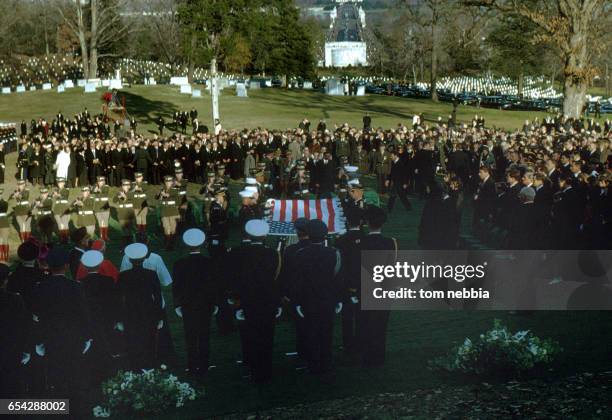 Members from the various US military services fold an American flag at President John F Kennedy's gravesite during his funeral at Arlington National...