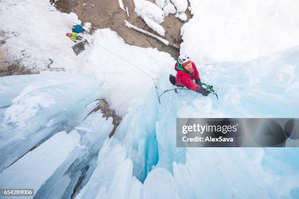 man ice climbing on vertical icicle using ice axe - belaying stock pictures, royalty-free photos & images