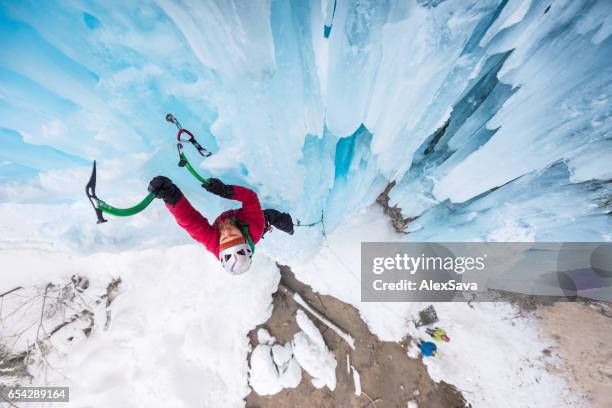 man climbing on vertical frozen waterfall - condição imagens e fotografias de stock