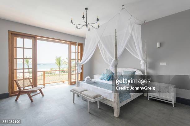 four poster bed with mosquito net in bright hotel room - rustic elegance stock pictures, royalty-free photos & images