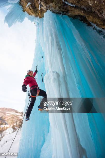 単一の氷の斧に保持男性のアイスクライマー - ice pick ストックフォトと画像