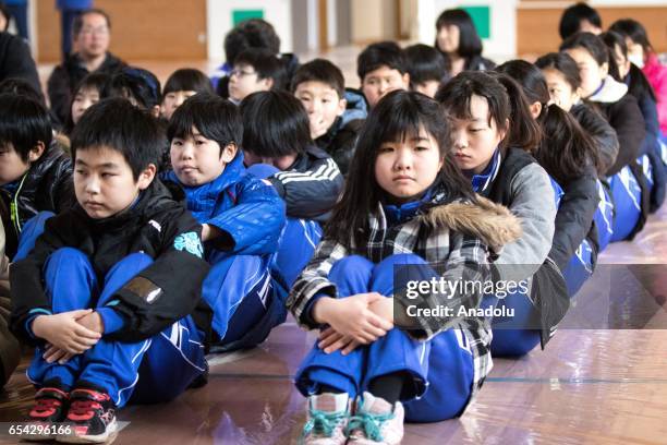 Students at the Hokuyou Elementary School listen to instructions of the officials during a missile evacuation drill on Friday, March 17 in Kitaura,...