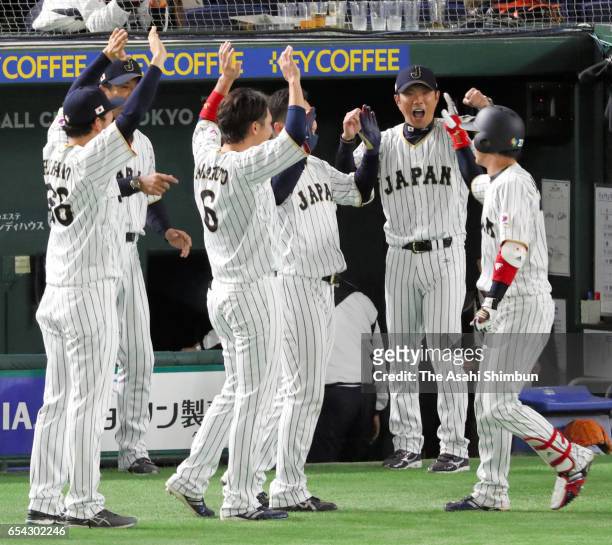 Designated hitter Tetsuto Yamada of Japan is congratulated by his team mates after hitting a two run homer in the bottom of the eighth inning during...