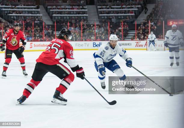 Tampa Bay Lightning Winger Gabriel Dumont stickhandles the puck against Ottawa Senators Defenceman Erik Karlsson during the NHL game between the...