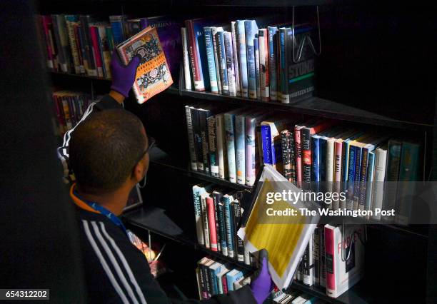 Library associate Caleb Bess pulls books from the shelves to be assessed at the Martin Luther King, Jr., Memorial Library on March 8, 2016 in...