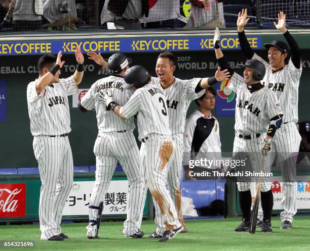 Outfielder Seiichi Uchikawa of Japan is congratulated by his team mates after hitting a sacrifice fly to make it 5-6 in the bottom of the eighth...